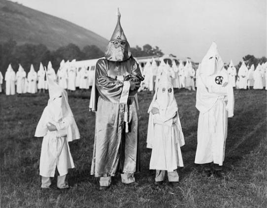 Razzismo nello sport. Georgia: tre bambini indossano l'uniforme bianca del Ku Klux Klan insieme al Dr. Samuel Green, Grand Dragon dell'organizzazione.