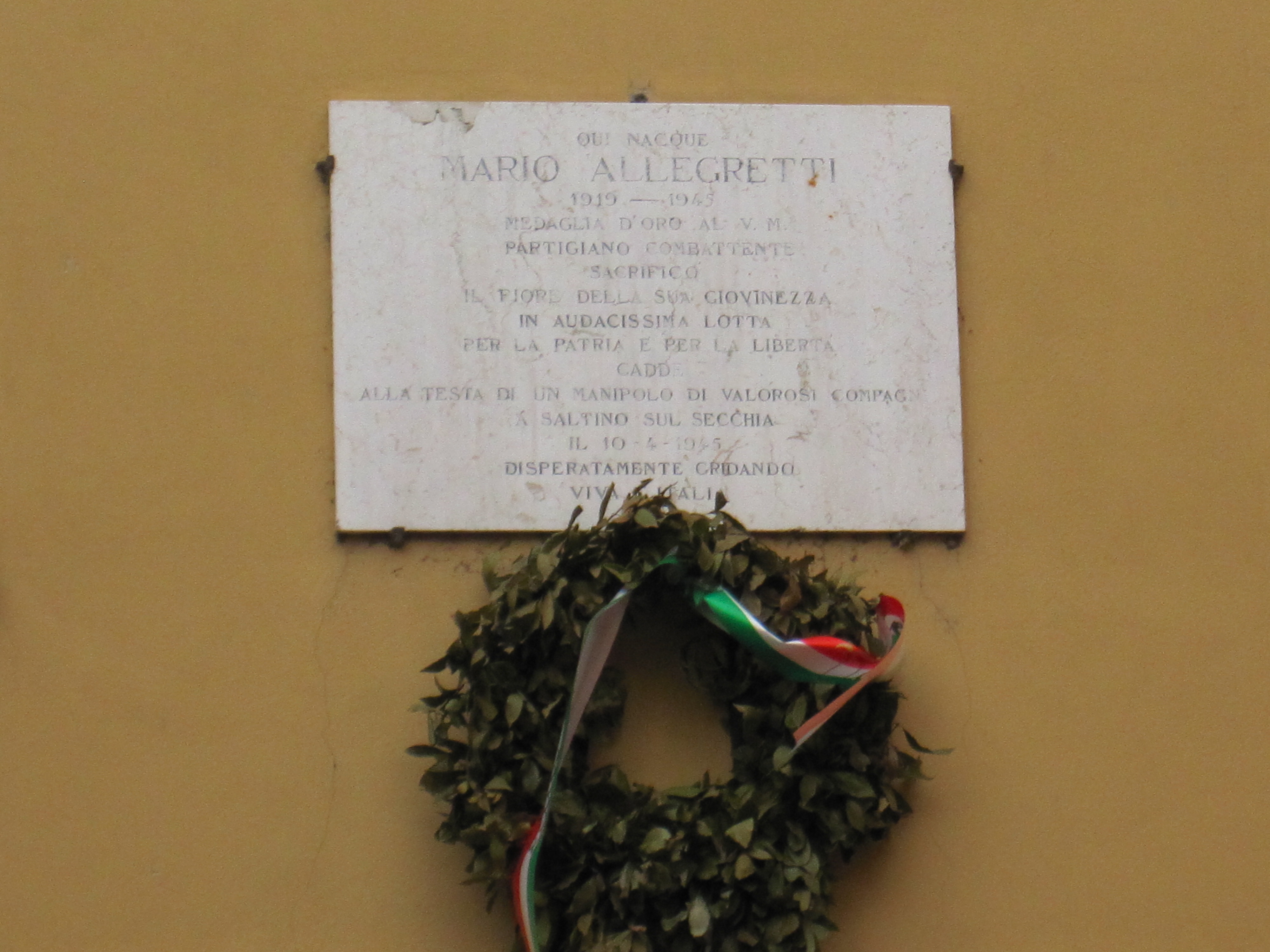 Lapide in memoria di Mario Allegretti, collocata sul muro esterno della sua casa natale a Vignola