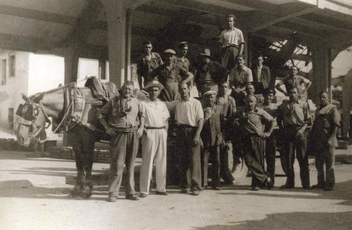 Storia di Vignola. La carovana facchini del mercato ortofrutticolo di Vignola in una foto del maggio 1945. Si stanno ancora rimuovendo le macerie dei bombardamenti aerei, eppure si riparte. Foto archivio Gruppo Mezaluna-Mario Menabue