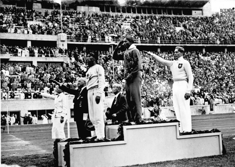 Jesse Owens sul gradino più alto del podio dopo la gara di salto in lungo alle Olimpiadi di Berlino 1936 - Bundesarchiv, Bild 183-G00630 / Unknown / CC-BY-SA 3.0 - sport e storia