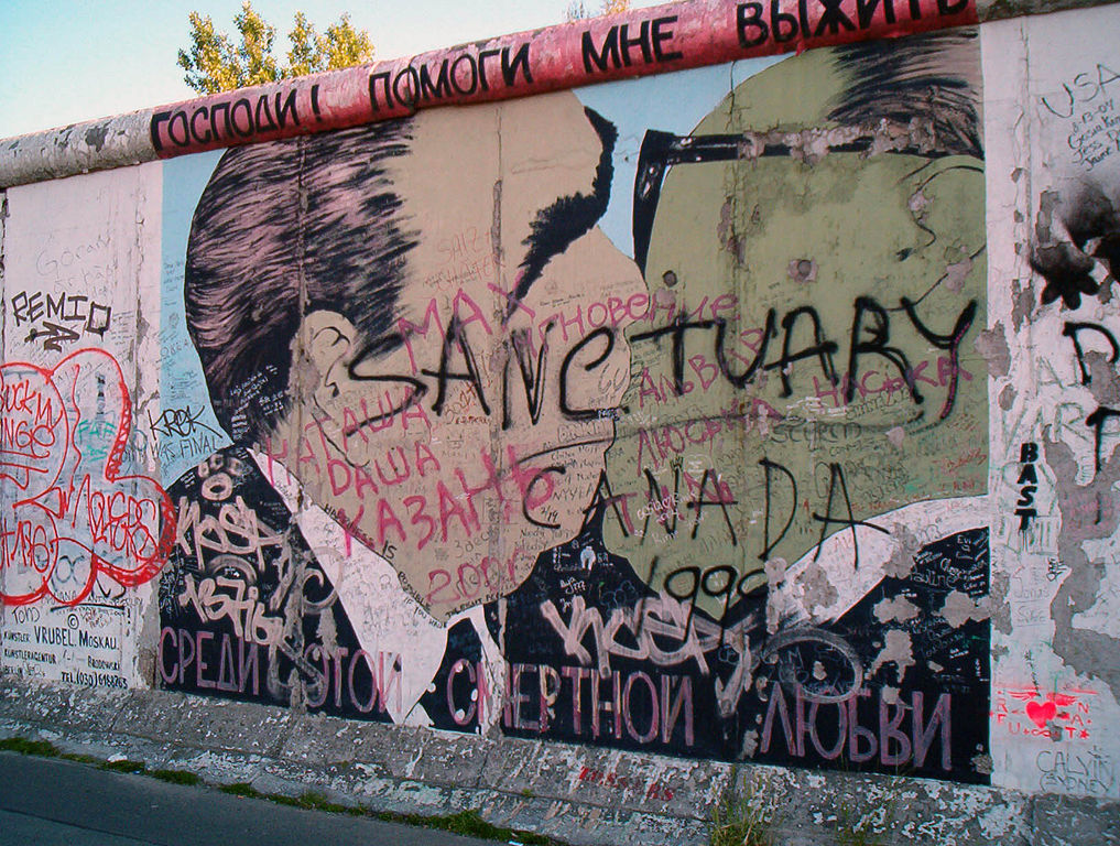 caduta del muro di Berlino. Il murale rappresenta il dittatore sovietico Leonid Brežnev e il leader della DDR Erich Honecker mentre si baciano. La scritta in alto, in russo dice: "Signore! Aiutami a sopravvivere a questo amore letale, ti prego". Foto di Victorgrigas via Wikimedia Commons